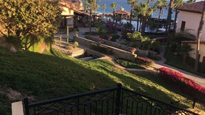 Ein Resort mit Poolbereich, Palmen und Meerblick.