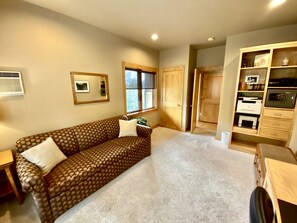 Relax in this cozy space with a sofa, side table, and storage cabinet.