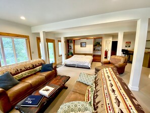Relax in this inviting living area with a large bed, sofa, and armchair.