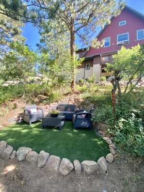 Relax in a serene outdoor space surrounded by lush greenery and a comfortable seating area.