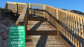Un malecón de madera que conduce a una zona de playa privada, con un letrero que indica que es propiedad privada y sin acceso de embarcaciones a Aransas Inn.