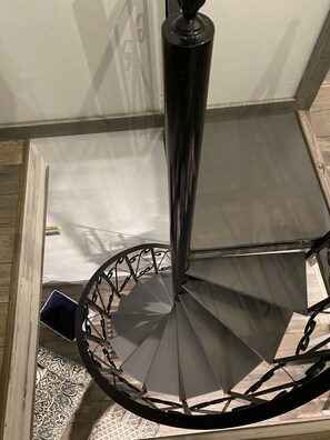 Eine Wendeltreppe mit Metallgeländer und einer zentralen Säule.
