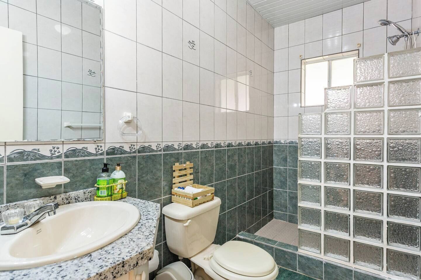A bathroom with a sink, toilet, and shower area.