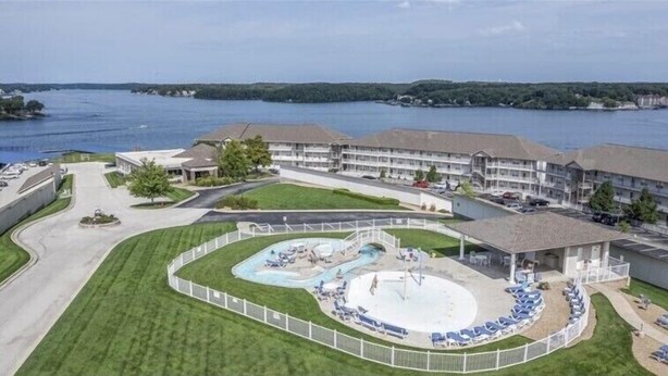 Un hotel con piscina, area coperta e vista sul lago.