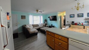 A compact living space with a kitchenette, a dining area, and a seating area with a sofa. - Welcome to Bayside Breeze! One Block From Town Beach, Walk to Waterfront Dining (Rock Hall)