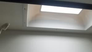 Et værelse med ovenlys og hvidt loft.