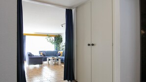 Ein Zimmer mit einer Couch, einem kleinen Tisch und einem Kleiderschrank.