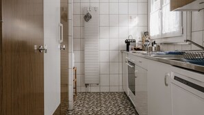 Eine moderne Küche mit weißen Schränken, einer gefliesten Spritzschutzleiste und einem gemusterten Boden.