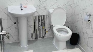 Een douche, handdoeken, zeep, toiletpapier