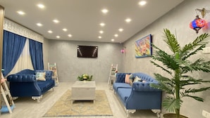 Una sala de estar moderna con dos sofás azules, una mesa de centro y una planta en maceta.