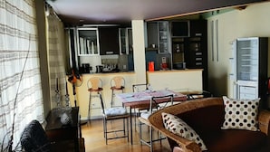 A compact living space with a dining area, kitchenette, and a sofa with patterned cushions. - Anjos Apartment - Central Lisbon (Lisboa)