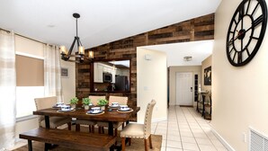 Un coin repas avec une table en bois, des chaises et un lustre.