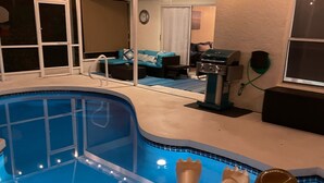 Une piscine avec un jacuzzi, un ventilateur de plafond et des guirlandes lumineuses.