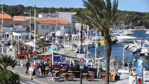 A marina with boats docked, a café area, and a sign indicating a parking area. - Self-catering cottage 400m from the beach, run by olive growers (Six-Fours-les-Plages)
