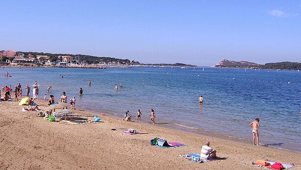 A beach with people swimming and sunbathing, a clear sky, and buildings in the background. - Self-catering cottage 400m from the beach, run by olive growers (Six-Fours-les-Plages)