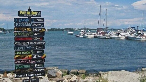 A signpost with distances to various cities and landmarks. - 1ST floor Condo NO STAIRS, beaches ,pool cedar point camp perry marsh parks,<br> (Oak Harbor)