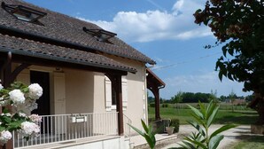A single-story house with a tiled roof, a covered porch, and a gravel driveway. - Spacious house with fireplace and large garden in Thiviers (Thiviers)