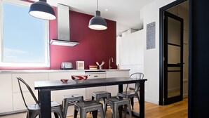 Eine moderne Küche mit Esstisch, Stühlen und einem großen Fenster.