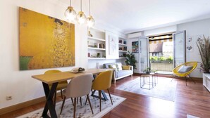 A modern living room with a dining area, open shelving, and a view to the outside. - Aire de La Concha | The Rentals Collection (San Sebastián)