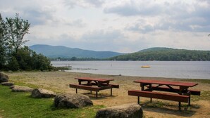 Un espace de pique-nique au bord du lac, équipé de bancs et de gros rochers.