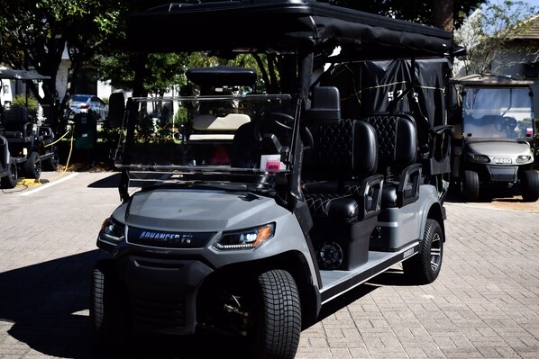 A grey off-road vehicle with a roof and side storage compartments.