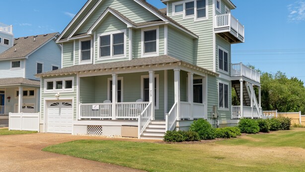 A two-story house with a front porch, a garage, and a small balcony on the upper floor. - Gone Coastal: Dog-Friendly (2 max), Private Pool (Corolla)