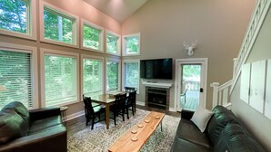A living room with a fireplace, a television, and a dining area. - Ski in on Boyneland Run, Slps 18, Fully remodeled (Boyne Falls)