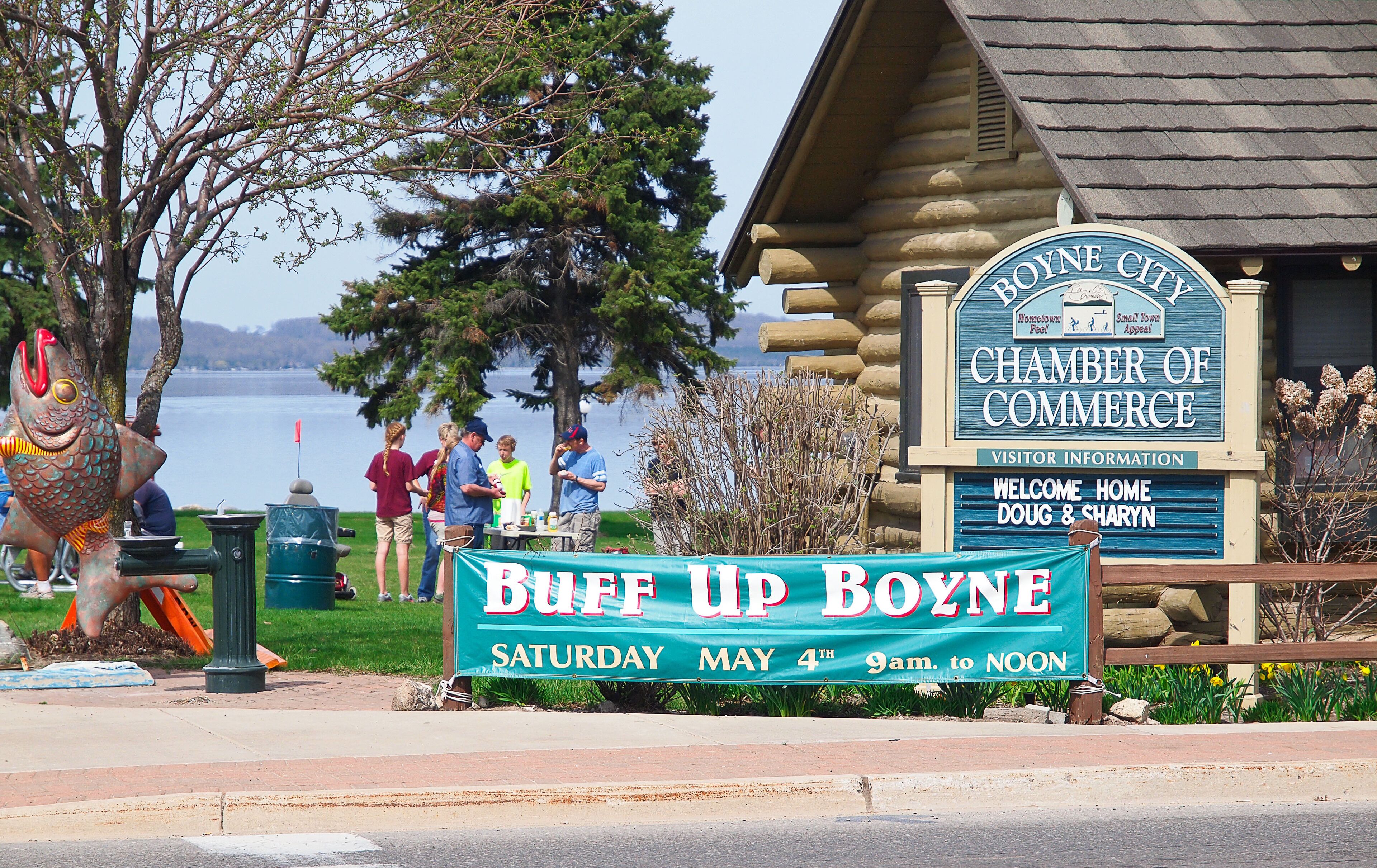 A sign for 'Buff Up Boone' with a view of a lake and a 'Chamber of Commerce' building.