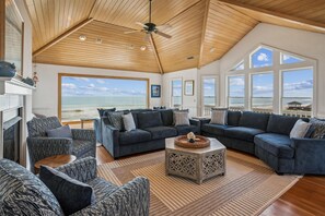 Relax in this spacious living area with a sofa, armchair, and coffee table, perfect for unwinding with a view of the ocean.