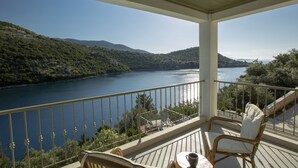 En balkon med udsigt over et sølandskab og bakker.