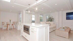 A modern kitchen with white cabinetry, a central island, and pendant lighting. - Arden House DT Mystic 3BR Lux Family Getaway (Mystic)