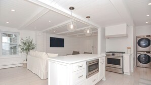 A modern kitchen with white cabinetry, a central island, stainless steel appliances, and pendant lighting. - Arden House DT Mystic 3BR Lux Family Getaway (Mystic)