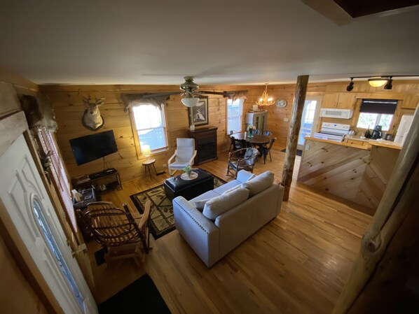 Interior acogedor de una cabaña con sala de estar, comedor y cocina.
