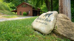 Una baita rustica con un cartello in pietra che riporta la scritta "Bobcat Run 501 Trivett Cir."