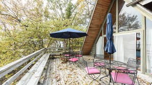 A wooden deck with outdoor furniture and a blue umbrella.