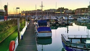 A marina with boats docked, a wooden walkway, and buildings in the background. - 3 bedroom accommodation in Ramsgate (Ramsgate)
