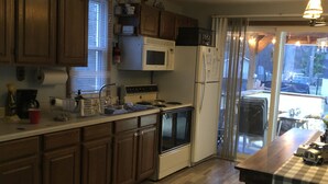 Une cuisine avec des armoires en bois, un four à micro-ondes, une cuisinière et un réfrigérateur.