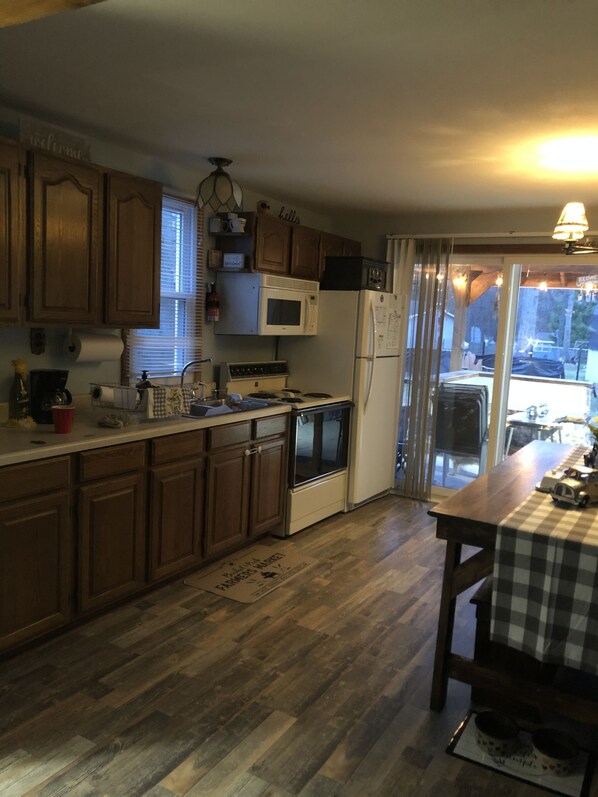A kitchen with wooden cabinets, a microwave, a stove, and a refrigerator.
