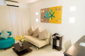 A living room with a sofa, coffee table, and a painting on the wall. - Bocagrande Cartagena De Indias (Cartagena)