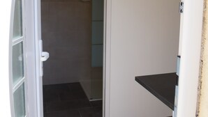 A bathroom with a shower, a towel rack, and a small countertop. - Duplex en Bord de mer Dans Residence Avec Piscine (CALCATOGGIO)