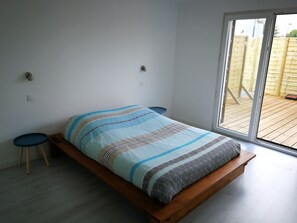 Ein Schlafzimmer mit einem Bett, einem kleinen Tisch und einer Bank.