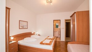 Ein Schlafzimmer mit einem hölzernen Bett, einem Nachttisch, einer Kommode und einem gerahmten Bild an der Wand.