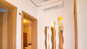 Ein Flur mit Holztür, Wandklimaanlage und Fliesenboden.