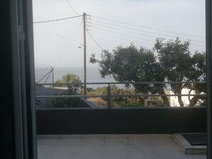 Un balcon avec vue sur la mer et une ligne électrique.