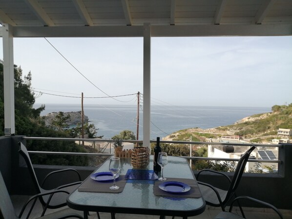 Un balcón con una mesa para dos, con vista al mar.