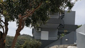 A stone pathway leading to a modern building with a staircase. - George place two-storey holiday home offers panoramic sea and mountain views. (Λυγαριά)