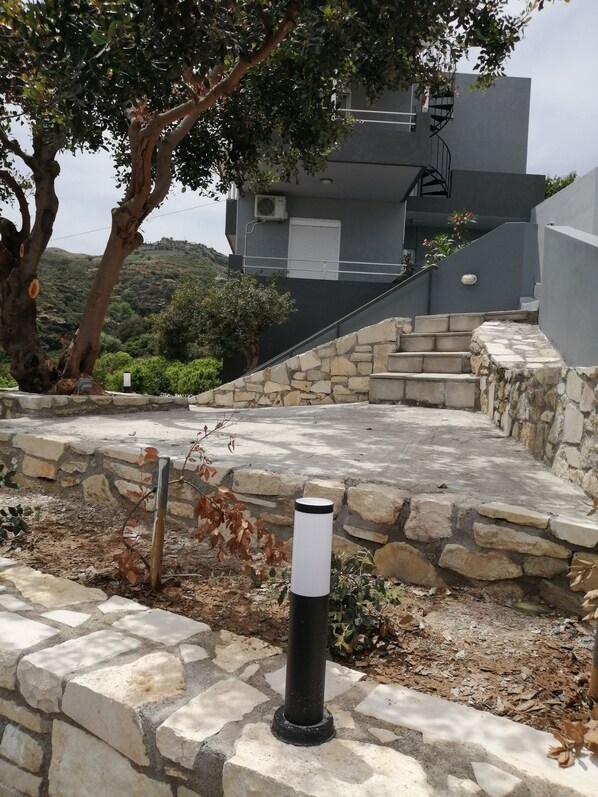 Un chemin de pierre mène à un bâtiment moderne doté d’un escalier.