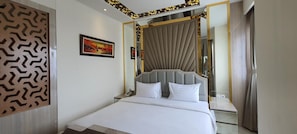 Une chambre d’hôtel comprenant un lit, une table de chevet, un miroir et un panneau décoratif sur le mur.
