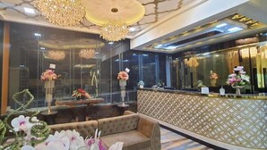 A reception area with a patterned wall, a sofa, and a reception desk.