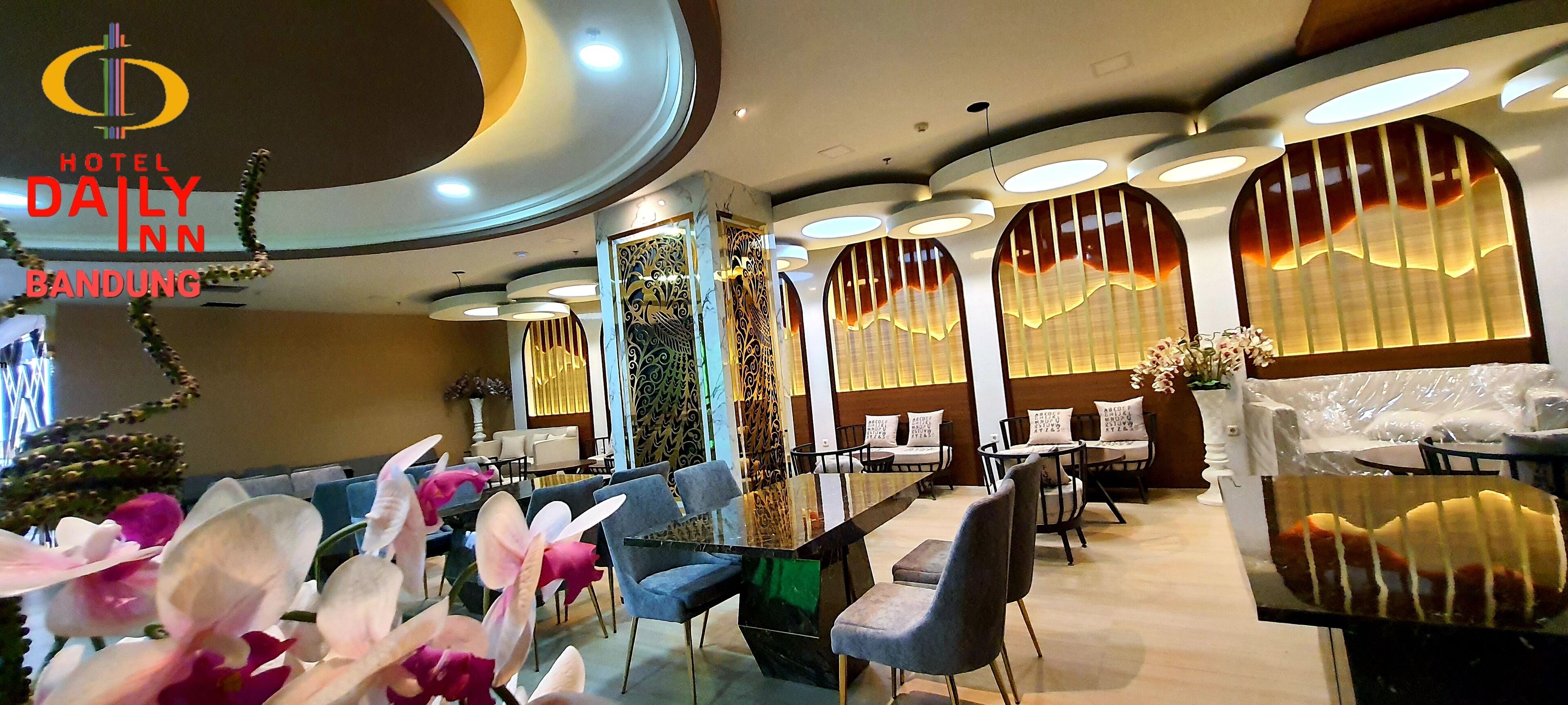 A modern hotel dining area with round tables, blue chairs, and decorative wall panels.